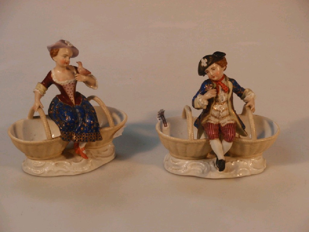 Appraisal: A pair of German porcelain figures seated on double baskets