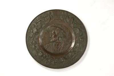 Appraisal: A large embossed and bronzed copper charger the centre with