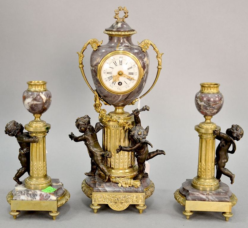 Appraisal: Three piece French clock set having bronze putti rouge marble