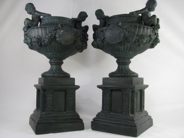 Appraisal: Pair of ornate patinated plaster urns or planters decorated with