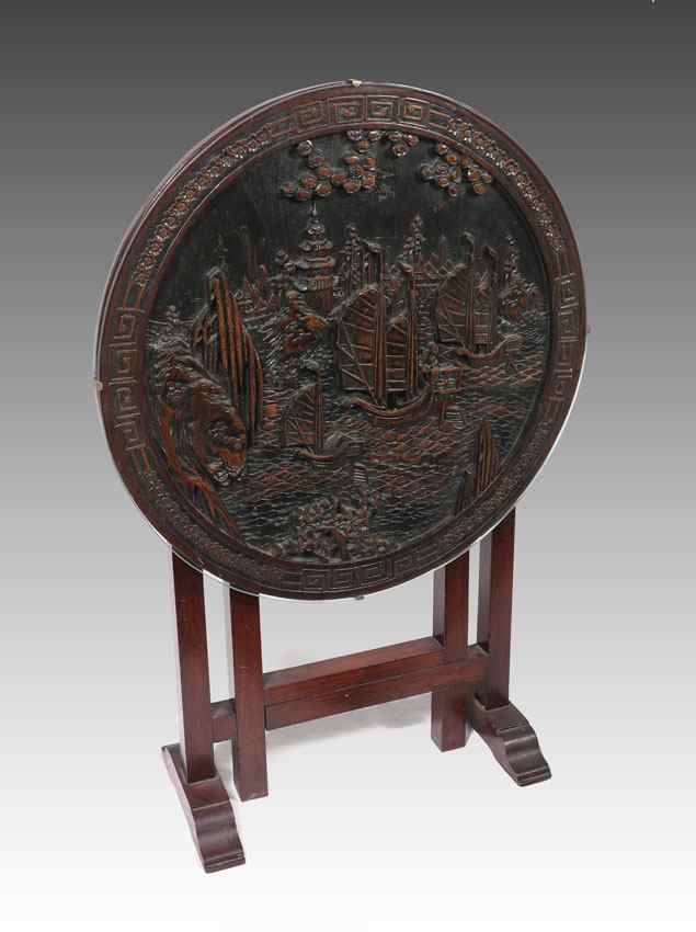 Appraisal: CARVED CHINESE TILT TOP TABLE Glass top over carved coastal