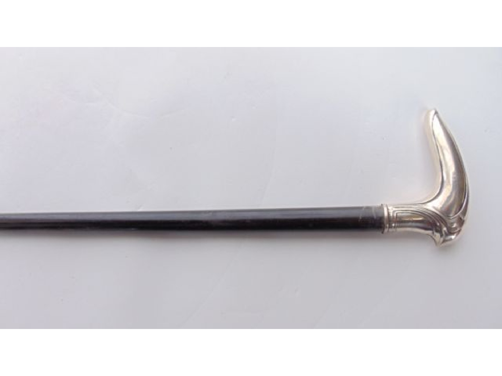 Appraisal: An ebonised walking cane terminating in an applied white metal