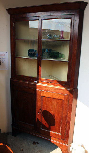 Appraisal: A TH CENTURY MAHOGANY CORNER CABINET two glazed doors above