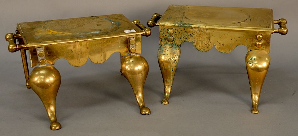 Appraisal: Two heavy brass footmen with two handles and downswept legs