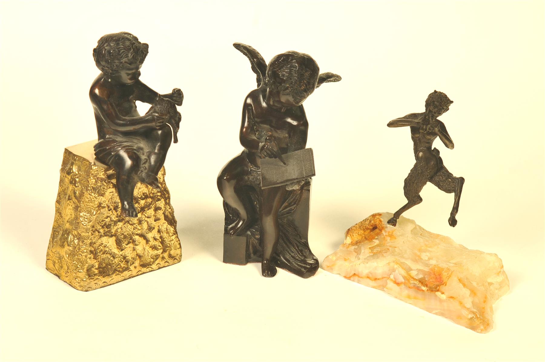 Appraisal: THREE BRONZE FIGURES European th century Seated child on rocky