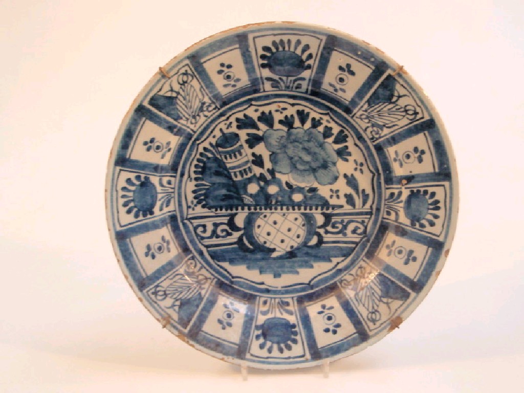 Appraisal: A Delft charger painted in blue with a vase of