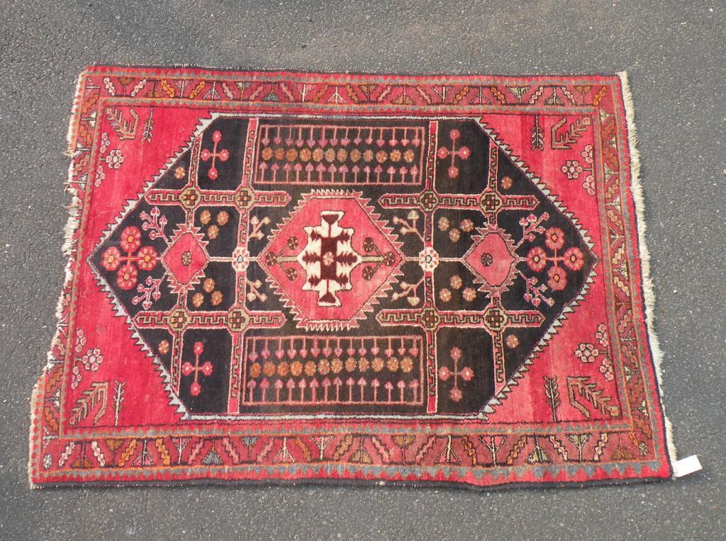 Appraisal: A Persian rug decorated with a central pole medallion on