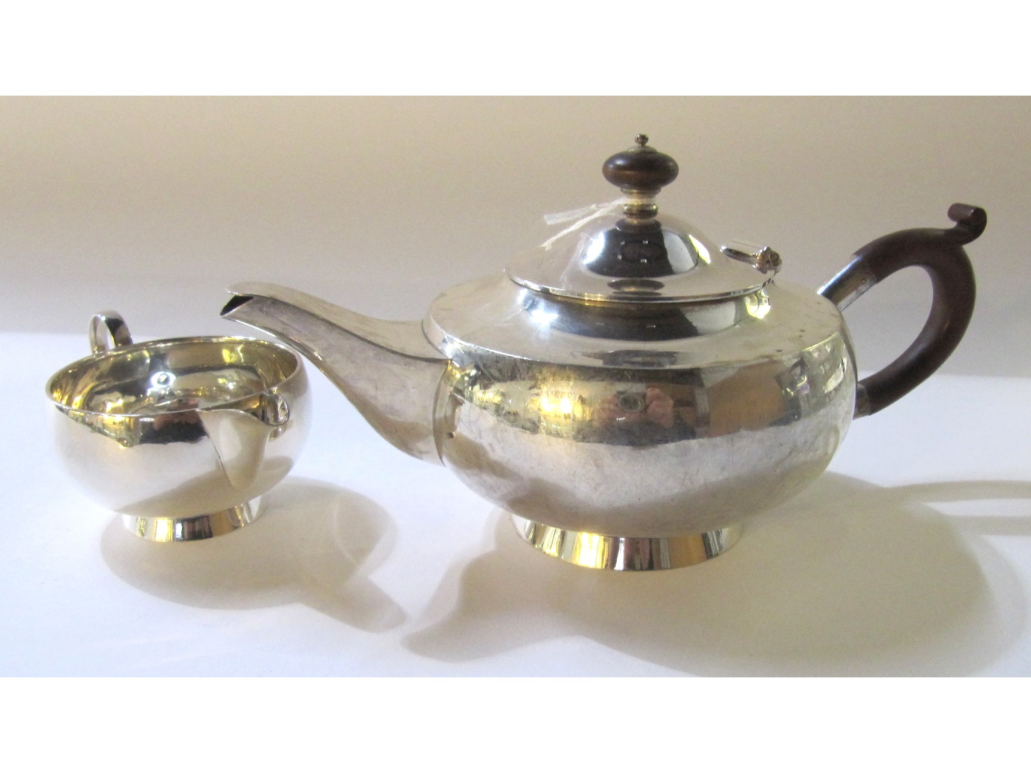 Appraisal: A silver teapot and matching cream jug Birmingham