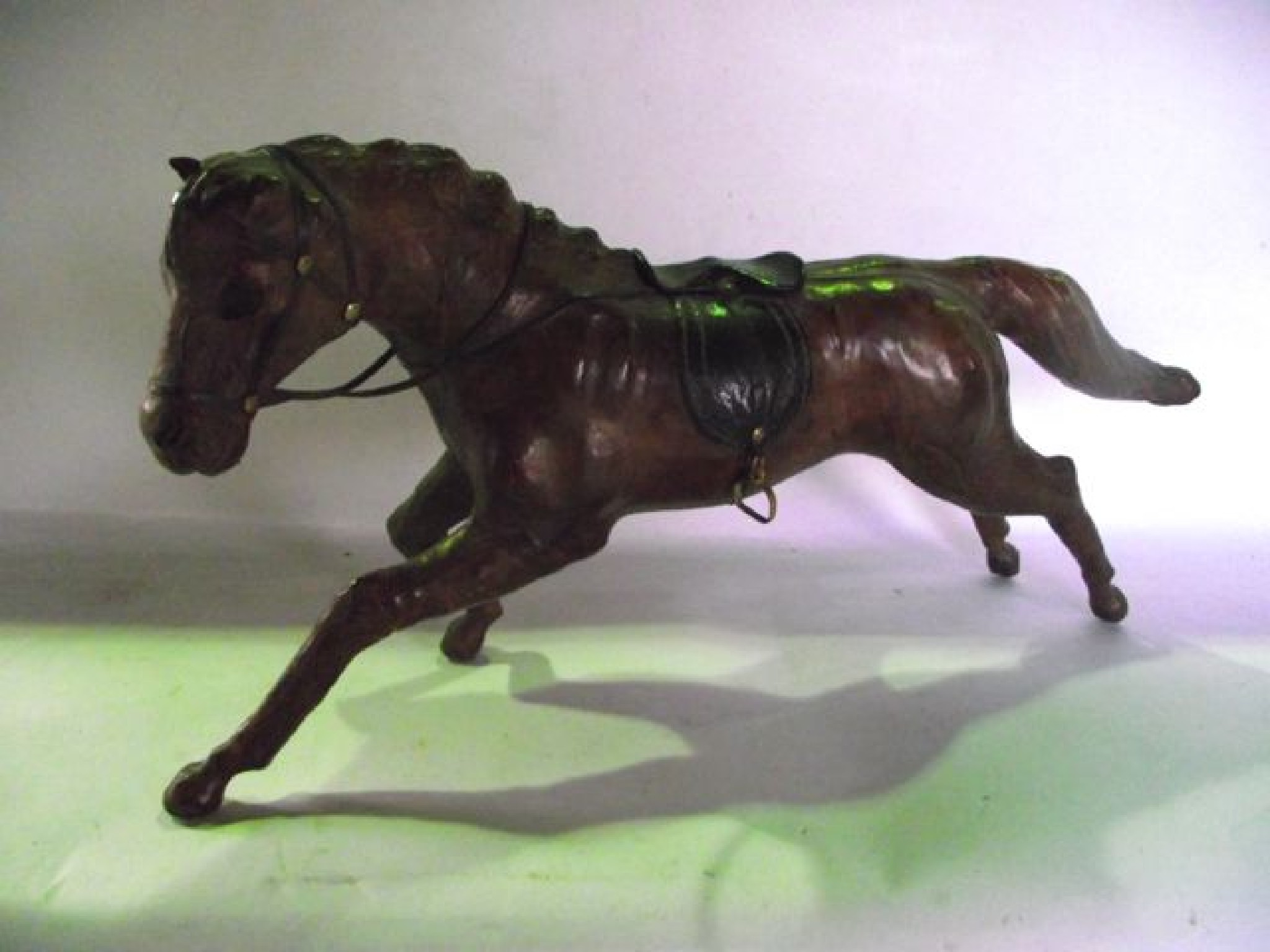 Appraisal: A tanned leather clad model of a galloping horse detailed