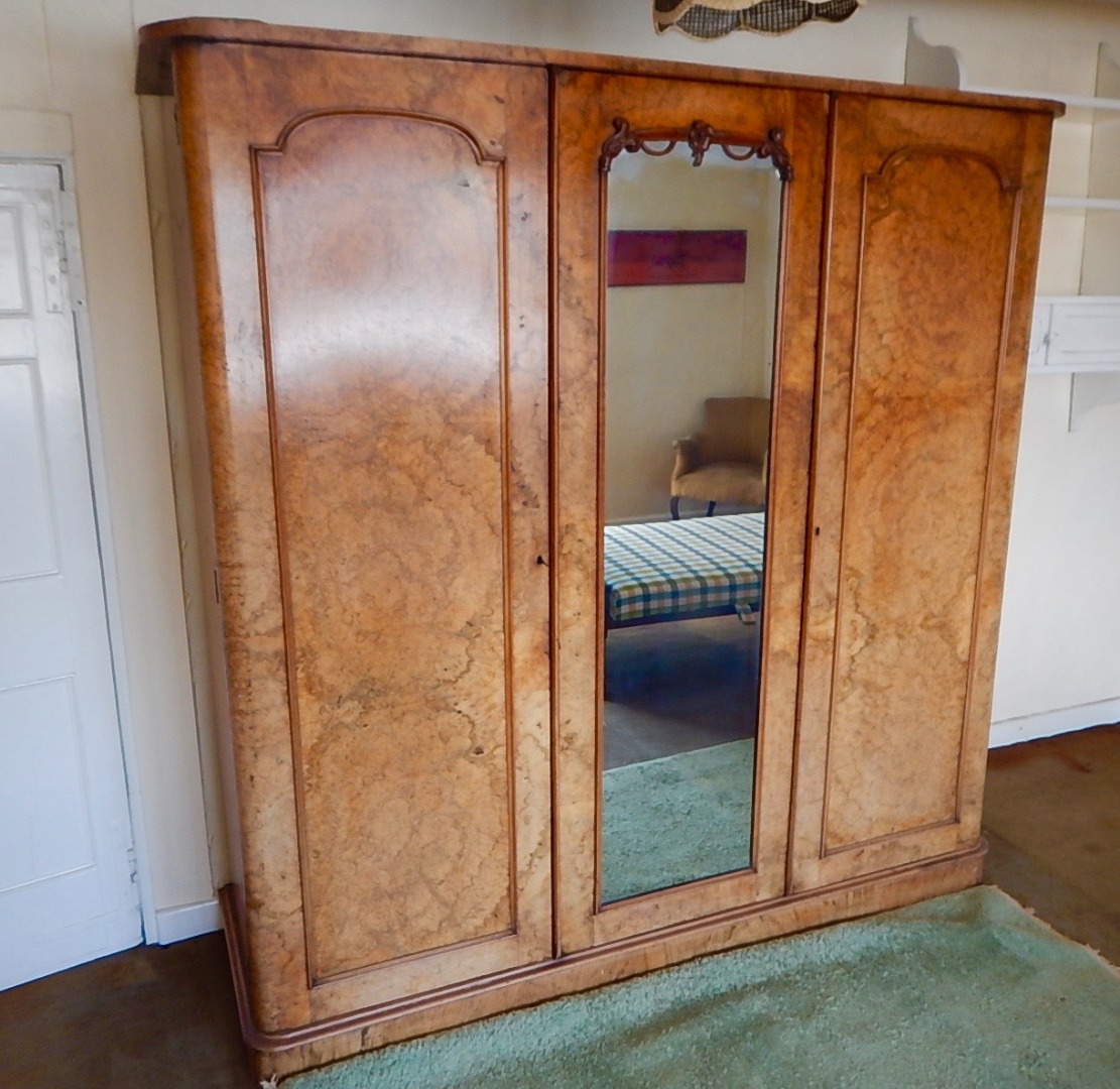 Appraisal: A Victorian figured walnut wardrobe enclosed by three doors with