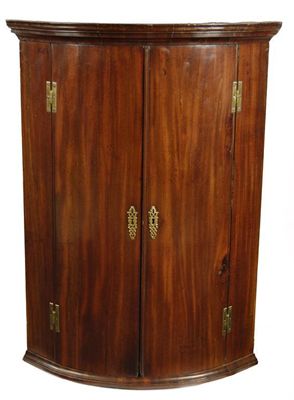 Appraisal: A George III mahogany bowfront corner cupboard the moulded cornice