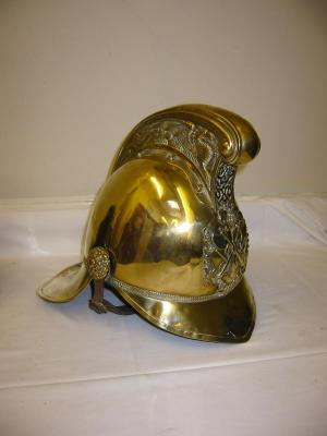 Appraisal: A BRASS FIREMAN'S HELMET the moulded scroll cockade embossed with