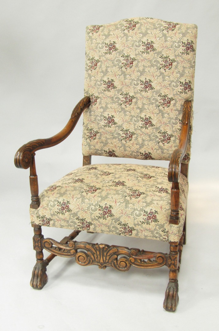 Appraisal: A Carolean style oak framed armchair with leaf carved scrolling