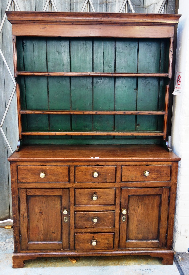 Appraisal: A George III stained pine dresser the enclosed three tier