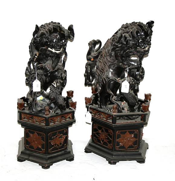 Appraisal: A pair of lacquered wood fu dogs Each with inlaid