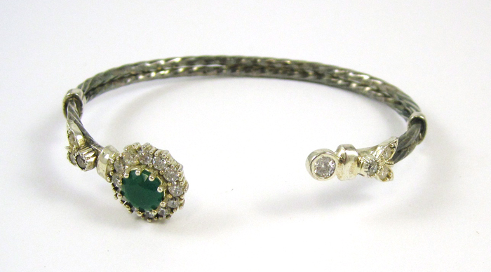 Appraisal: EMERALD AND SILVER CUFF BRACELET featuring a round-cut green emerald