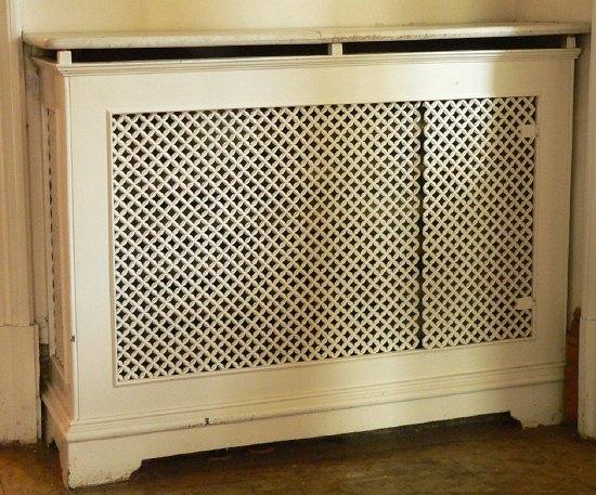 Appraisal: A single panelled pierced cast radiator surround with marble top