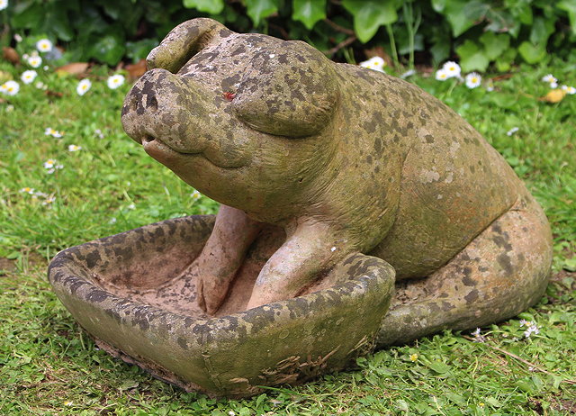 Appraisal: A WEATHERED TERRACOTTA SCULPTURE OF A PIG and feeding trough