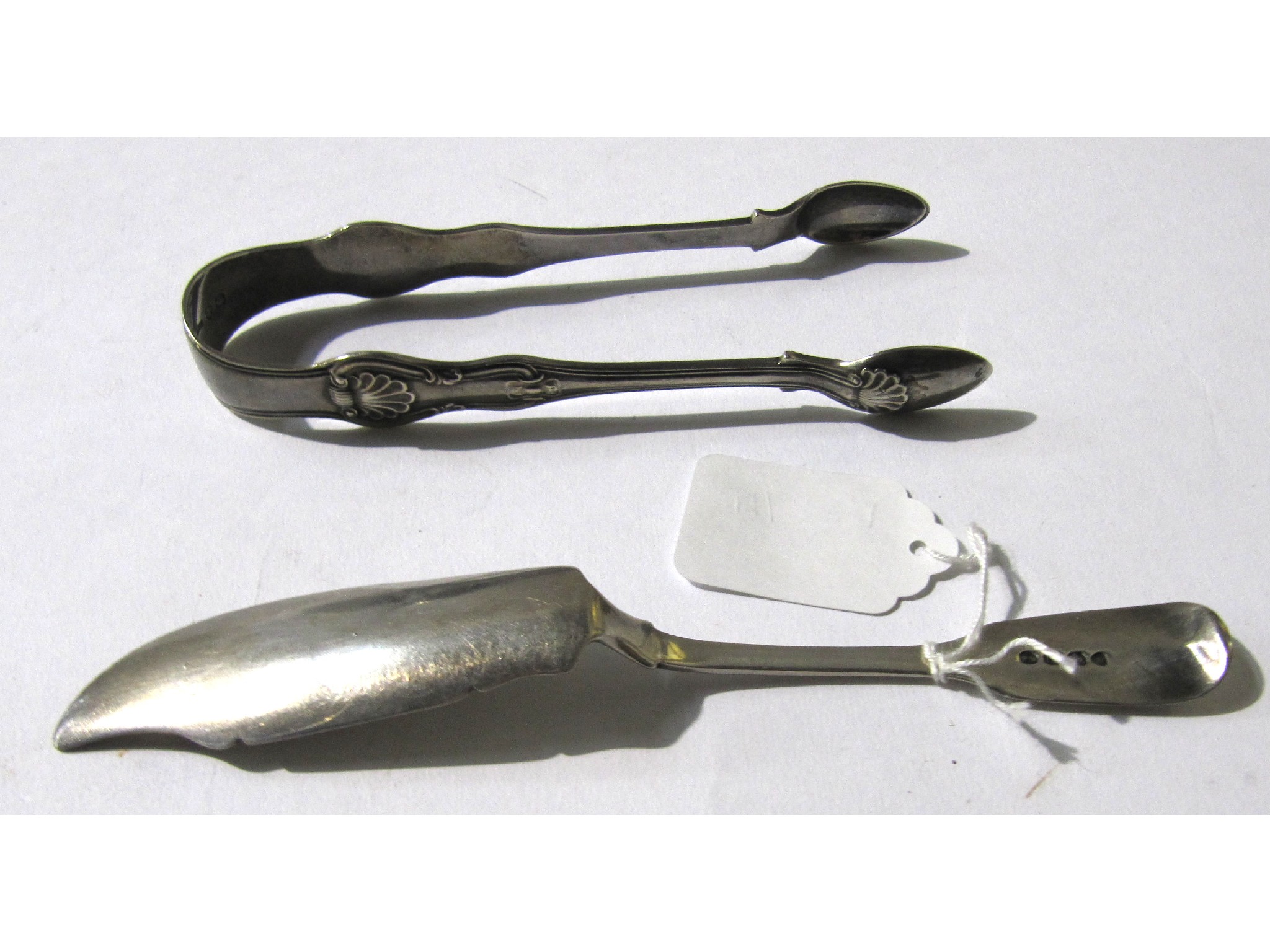 Appraisal: A lot comprising a pair of silver sugar tongs and