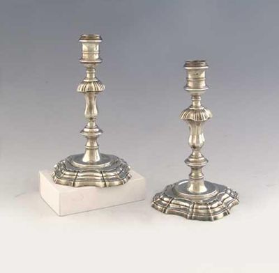 Appraisal: A pair of George II cast candlesticks on shaped square