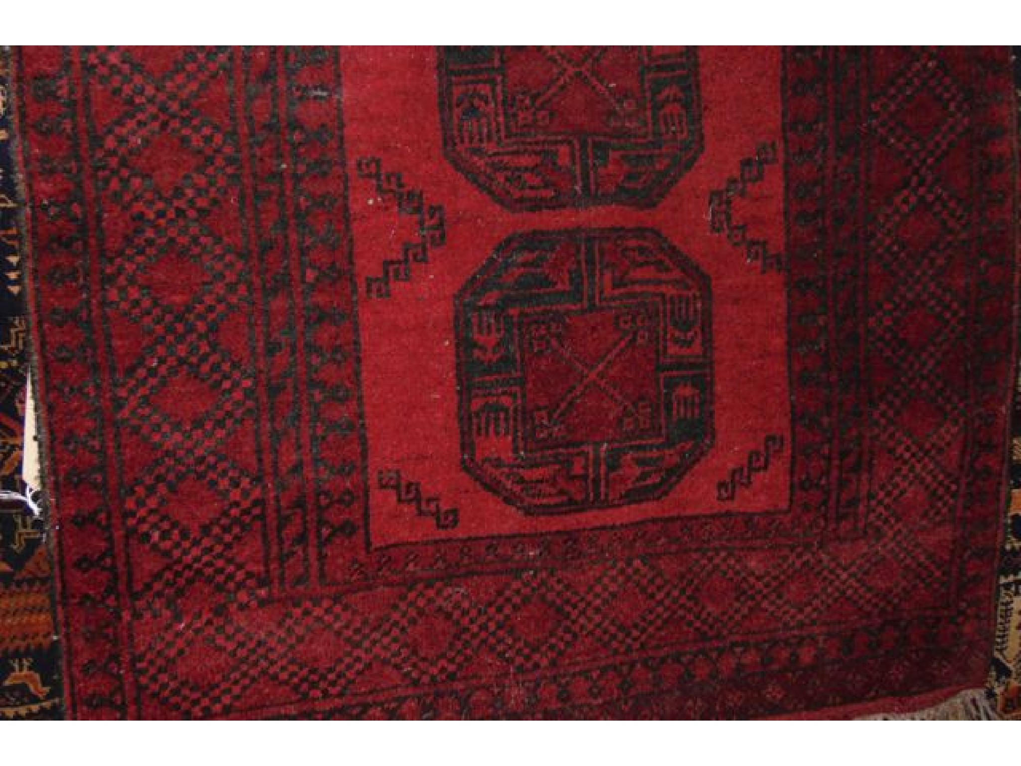 Appraisal: An Afghan red ground rug with triple medallion centre set