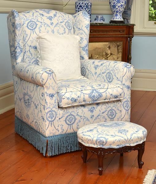 Appraisal: BLUE AND WHITE UPHOLSTERED WINGBACK ARMCHAIR WITH FOOT STOOL