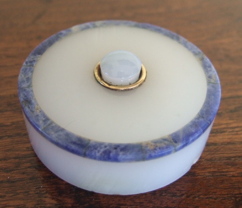 Appraisal: A white onyx and lapis lazuli banded circular bell-push retailed