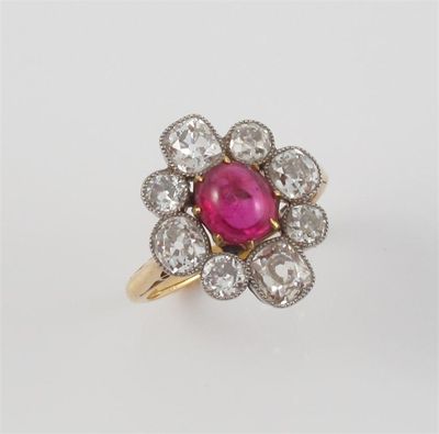 Appraisal: A cabochon ruby and diamond cluster ring The oval shaped