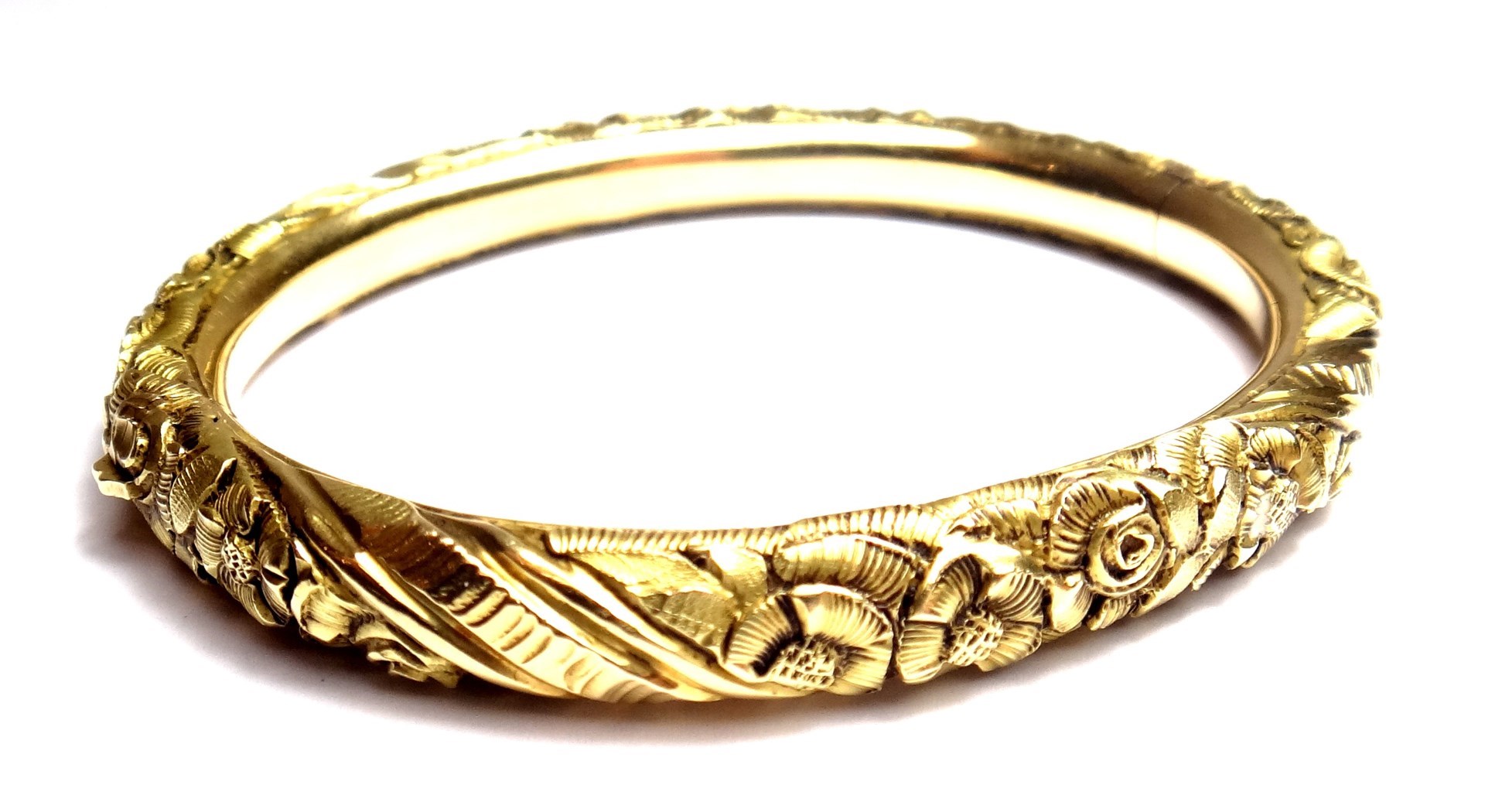 Appraisal: A gold oval hinged bangle the back and the front