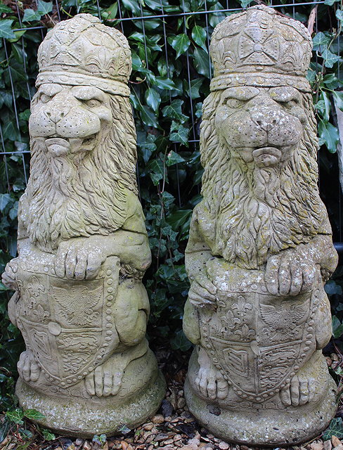 Appraisal: TWO COMPOSITE STONE LION STATUES each lion wearing a crown