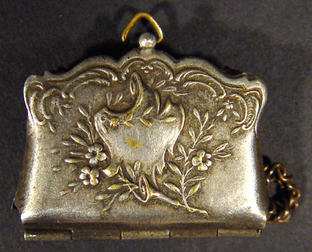 Appraisal: Miniature silver metal purse the floral embossed outer panels opening