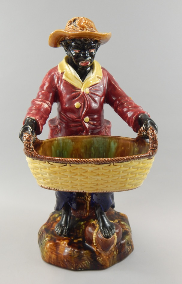 Appraisal: A thC English majolica Blackamoor figure wearing a red coat