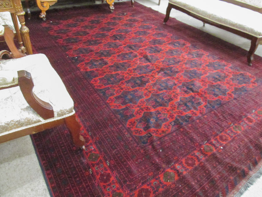 Appraisal: AN AFGHAN BELOUCH CARPET featuring a field of repeating geometric