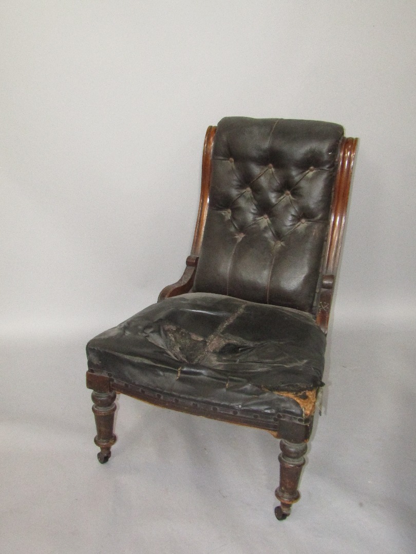 Appraisal: A Victorian mahogany lady's armchair with button leather back and