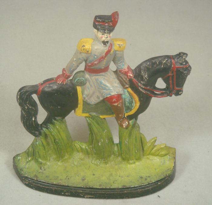 Appraisal: Cast iron doorstop colorful soldier on horseback on green grassy