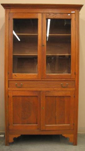 Appraisal: An antique oak kitchen cupboard glass doors in top one