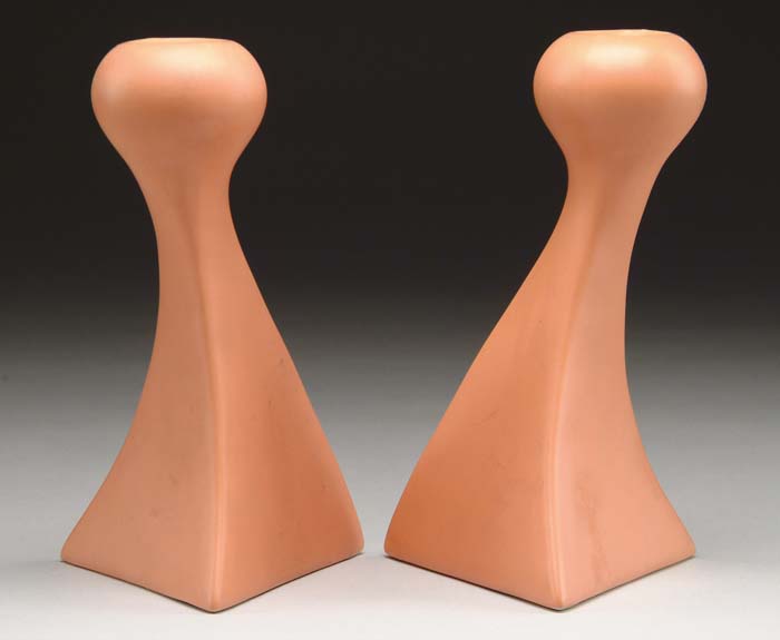 Appraisal: STYLIZED ART DECO POTTERY CANDLESTICKS The creamy orange sticks each