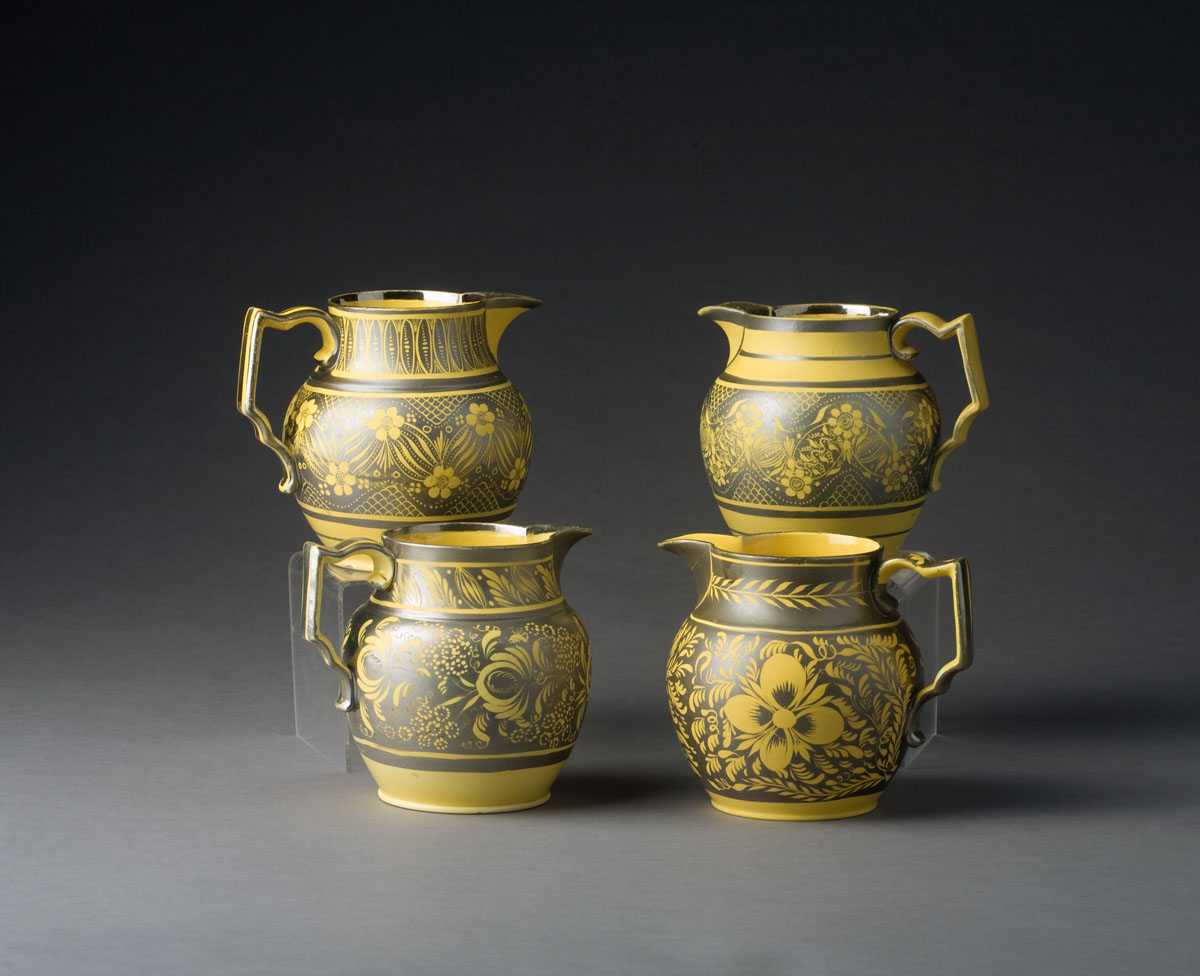 Appraisal: FOUR ENGLISH YELLOW-GLAZED SILVER RESIST JUGS CIRCA - Resisted in