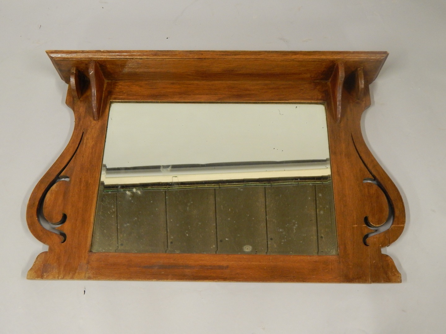 Appraisal: An Art Nouveau oak overmantel mirror with a shelf top