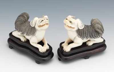 Appraisal: A Pair of Carved Ivory Foo Dog Figurines Depicted in