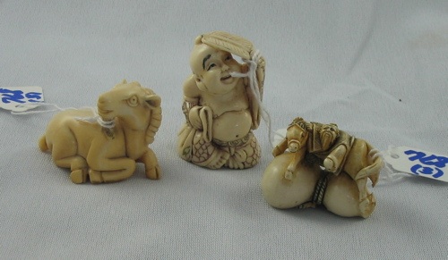 Appraisal: THREE IVORY HAND CARVED NETSUKE a stylized riling ram a