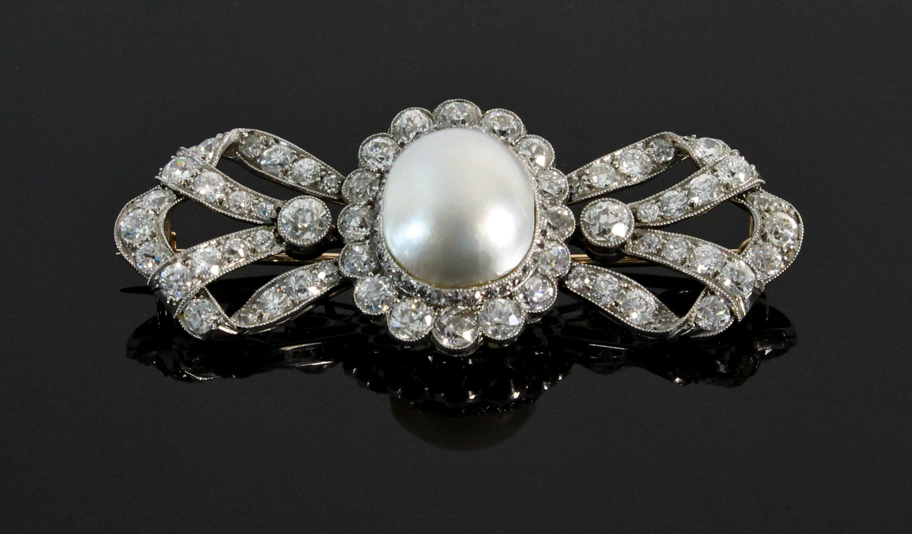 Appraisal: A Victorian diamond and natural blister pearl brooch of bow