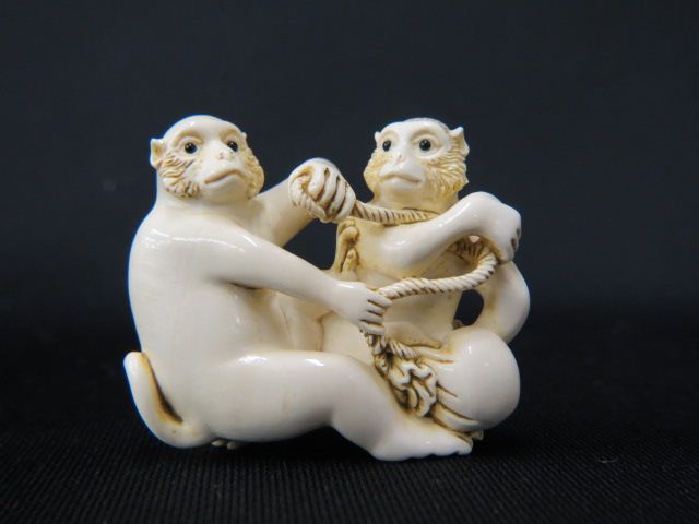 Appraisal: Carved Ivory Netsuke of Two Monkeys with a peach onyx