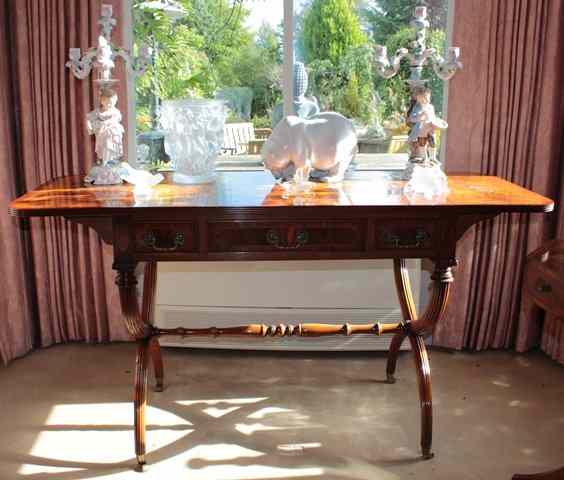 Appraisal: A REGENCY STYLE MAHOGANY SOFA TABLE with cross banded top