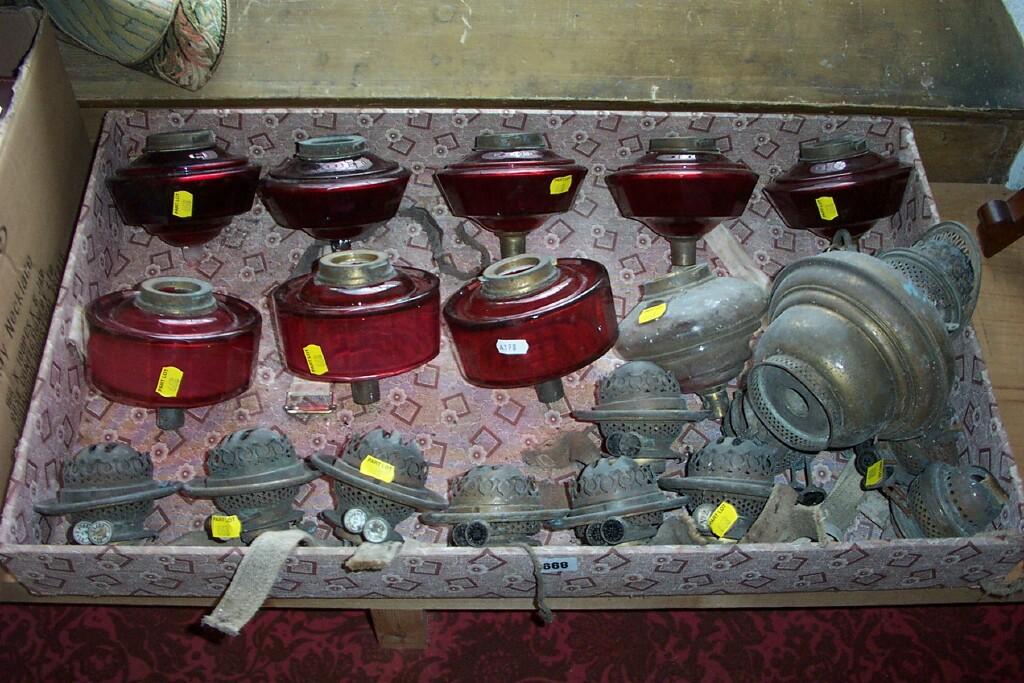 Appraisal: A quantity of oil lamp fittings including cranberry glass reservoirs