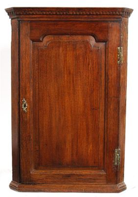 Appraisal: A George III oak hanging corner cupboard with an arched