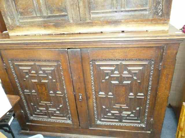 Appraisal: A LARGE ANTIQUE OAK CUPBOARD the twin panelled doors with