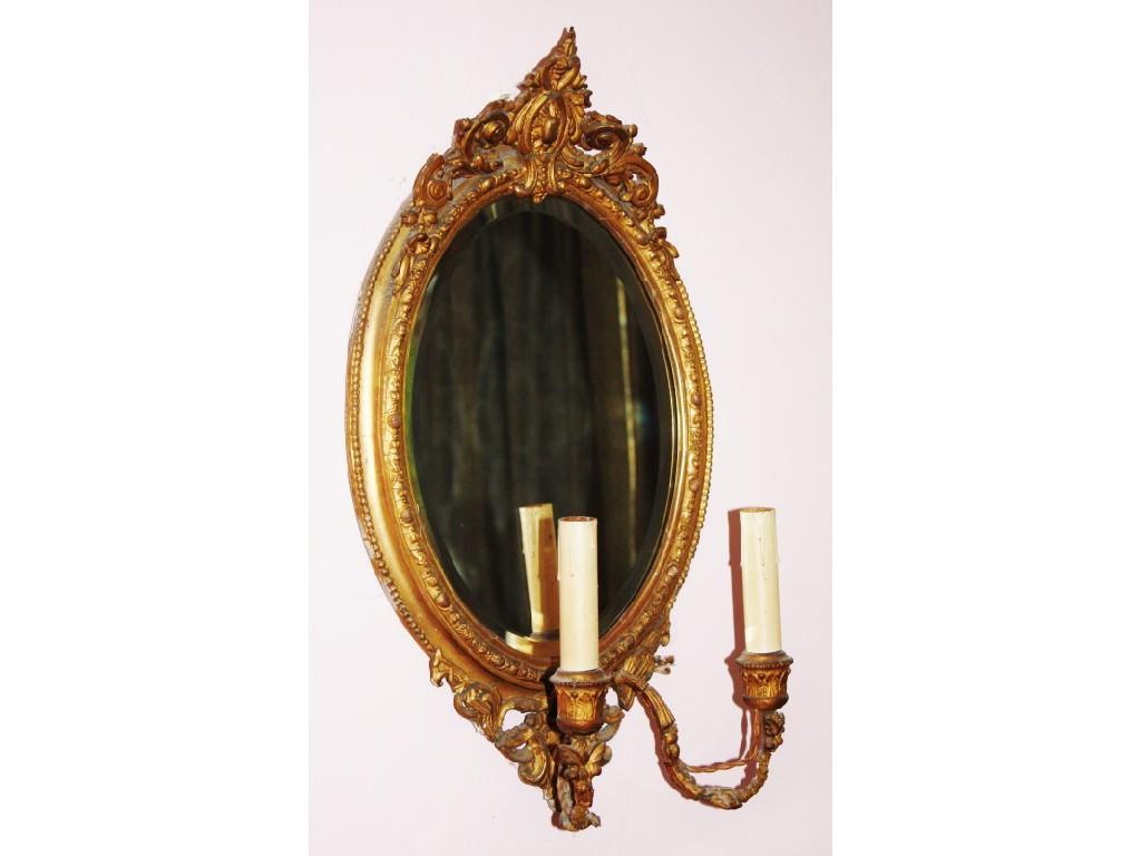 Appraisal: A thC oval girandole mirror with gilt gesso frame supporting