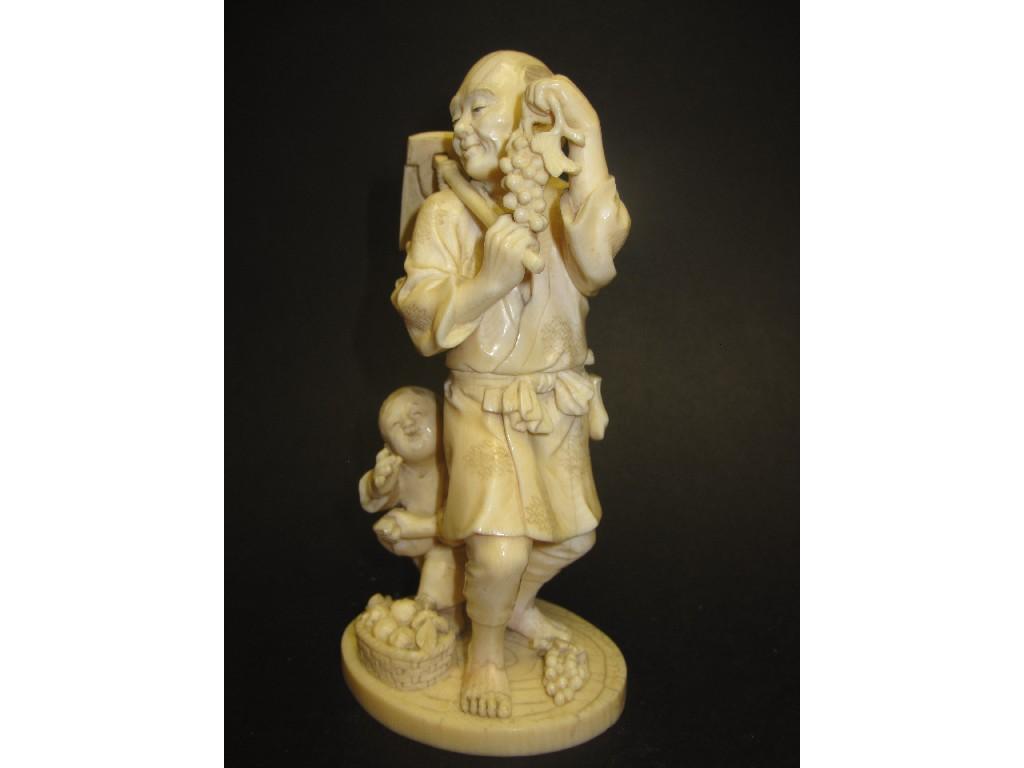 Appraisal: A Japanese carved ivory Standing Figure and Child with implement