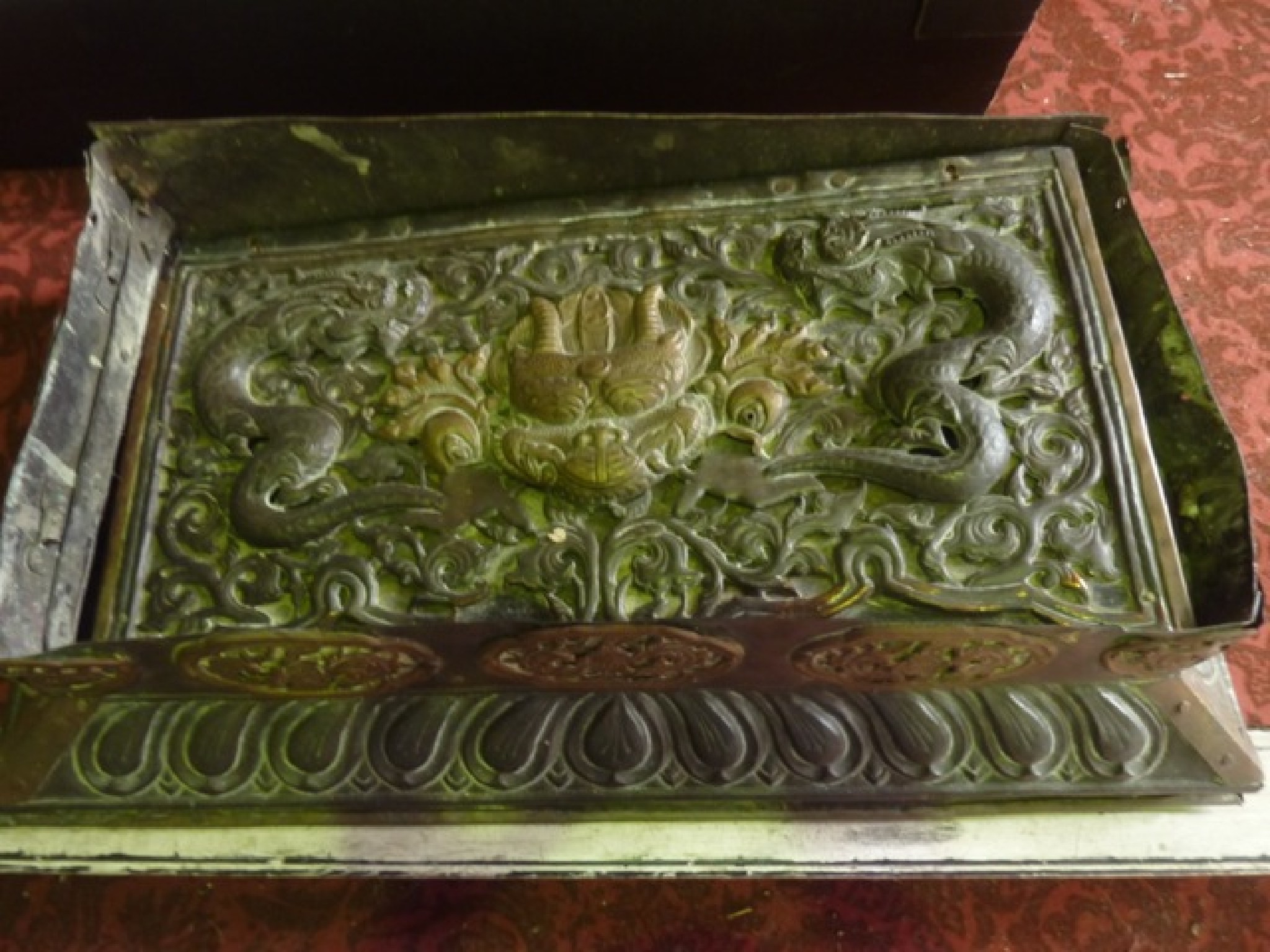 Appraisal: A Chinese brass panel with embossed detail of writhing dragon